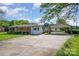 Charming single-story home with brick and siding exterior, long driveway, and a carport on a sunny day at 319 Glenhaven Dr, Charlotte, NC 28214