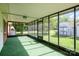 Enclosed sunroom with green carpet, screened windows, and view of the backyard at 319 Glenhaven Dr, Charlotte, NC 28214