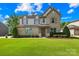 Charming two-story home with a well-manicured lawn, beautiful landscaping, and inviting front entrance at 3918 Halcyon Dr, Huntersville, NC 28078