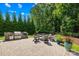 Outdoor kitchen with stone surround, grill, and adjacent fire pit for relaxation and outdoor living at 3918 Halcyon Dr, Huntersville, NC 28078
