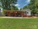 Backyard view of a single-story home with a covered patio and well-maintained lawn at 3951 Whitehall Dr, Charlotte, NC 28208