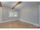 Bright bedroom features hardwood floors, wood beam ceiling and large window at 3951 Whitehall Dr, Charlotte, NC 28208
