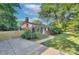 Charming front exterior featuring mature trees, sidewalk and fenced driveway at 3951 Whitehall Dr, Charlotte, NC 28208