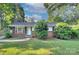 Charming brick home with mature landscaping and sidewalk to front door at 3951 Whitehall Dr, Charlotte, NC 28208