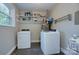 Bright laundry room featuring a washer, dryer, and storage shelves at 3951 Whitehall Dr, Charlotte, NC 28208