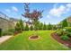Beautifully landscaped backyard with lush green grass and manicured flower beds creates a serene outdoor space at 4527 Waylon Ave, Fort Mill, SC 29715