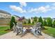 Outdoor entertaining space with a stone fire pit, comfortable seating, and lush landscaping at 4527 Waylon Ave, Fort Mill, SC 29715