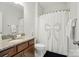 Bright bathroom with granite countertops, wood cabinets, and a shower with a decorative curtain at 4527 Waylon Ave, Fort Mill, SC 29715