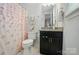 Charming bathroom with dark wood vanity and shower with floral curtain at 4527 Waylon Ave, Fort Mill, SC 29715
