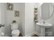 Cozy powder room featuring a pedestal sink, decorative shelves, and charming artwork at 4527 Waylon Ave, Fort Mill, SC 29715