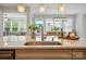 Close-up of kitchen island featuring a modern faucet and stainless steel sink overlooking outdoor dining at 4527 Waylon Ave, Fort Mill, SC 29715
