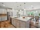 Open kitchen featuring a large island with pendant lighting, stainless steel appliances and access to the dining area at 4527 Waylon Ave, Fort Mill, SC 29715
