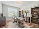 Well-lit home office featuring a modern desk, decorative shelving, and a window with natural light at 4527 Waylon Ave, Fort Mill, SC 29715
