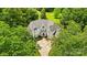 Aerial view of stately home nestled amongst lush trees, featuring a circular driveway and expansive lawn at 469 Valley Run Dr, Waxhaw, NC 28173