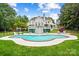 Beautiful backyard with a large pool, landscaped grounds, and a view of the house at 469 Valley Run Dr, Waxhaw, NC 28173