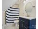 Bathroom with blue vanity, round mirror, and shower with a blue and white striped curtain at 469 Valley Run Dr, Waxhaw, NC 28173
