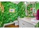 Stylish powder room features bold banana leaf wallpaper, marble countertops, and brass fixtures at 469 Valley Run Dr, Waxhaw, NC 28173