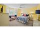 Bright bedroom features sunny yellow walls, ceiling fan, and a sitting area near sunny bay window at 469 Valley Run Dr, Waxhaw, NC 28173