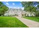 Stunning white brick home with well-manicured lawn, a circular driveway, and inviting curb appeal at 469 Valley Run Dr, Waxhaw, NC 28173