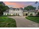 Elegant white home with porte cochere, balcony, manicured landscaping, and inviting entryway at 469 Valley Run Dr, Waxhaw, NC 28173