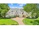 Beautiful white brick home featuring a lush green lawn, stately trees, and a welcoming driveway at 469 Valley Run Dr, Waxhaw, NC 28173