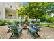 A circular fire pit is surrounded by green wooden chairs with blue cushions in this backyard space at 469 Valley Run Dr, Waxhaw, NC 28173