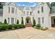 Close up of home's façade featuring brick, a Juliet balcony, arched entryway, and manicured landscaping at 469 Valley Run Dr, Waxhaw, NC 28173