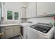 Clean laundry room with gray cabinets, stainless appliances, and a sunny window at 469 Valley Run Dr, Waxhaw, NC 28173