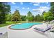 A luxurious backyard pool with a fountain, surrounded by lush landscaping and lounge chairs at 469 Valley Run Dr, Waxhaw, NC 28173