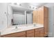 Large bathroom featuring a large mirror, wooden cabinets, and a double sink vanity at 511 Donatello Ave, Charlotte, NC 28205