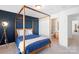 This bedroom features a modern canopy bed, blue accent wall and an ensuite bathroom for added privacy at 511 Donatello Ave, Charlotte, NC 28205