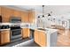Well-lit kitchen featuring stainless steel appliances, light wood cabinets, and an island with a white countertop at 511 Donatello Ave, Charlotte, NC 28205