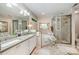 Bright bathroom boasts a large soaking tub, tiled walk-in shower, double vanity, and granite counters at 5208 Black Oak Ln, Waxhaw, NC 28173