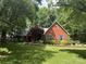 Charming red brick home featuring a well-manicured lawn, mature trees, and colorful landscaping at 5208 Black Oak Ln, Waxhaw, NC 28173