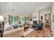 Spacious living room featuring a cozy fireplace, hardwood floors, vaulted ceiling and plenty of natural light at 5208 Black Oak Ln, Waxhaw, NC 28173
