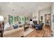 Spacious living room featuring a cozy fireplace, hardwood floors, vaulted ceiling and plenty of natural light at 5208 Black Oak Ln, Waxhaw, NC 28173