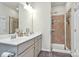 Bathroom featuring a dual vanity with shower stall, tile surround, and glass doors at 5391 Orchid Bloom Dr, Fort Mill, SC 29707
