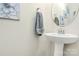 A clean, elegant bathroom with pedestal sink, a grey towel, and tasteful artwork at 5391 Orchid Bloom Dr, Fort Mill, SC 29707