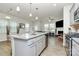 Open-concept kitchen with island overlooking the living area and a view of the fireplace at 5391 Orchid Bloom Dr, Fort Mill, SC 29707