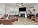 Bright living room with luxury vinyl flooring, a cozy fireplace, and a comfy leather sectional at 5391 Orchid Bloom Dr, Fort Mill, SC 29707