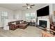 Bright living room with luxury vinyl flooring, a cozy fireplace, and a comfy leather sectional at 5391 Orchid Bloom Dr, Fort Mill, SC 29707