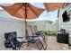 This patio area is set up for relaxing, with chairs, an umbrella, and a spot for outdoor entertainment at 5391 Orchid Bloom Dr, Fort Mill, SC 29707