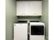 Convenient laundry room with modern washer, dryer, and bright white cabinets at 5951 Carrollton Ln, Charlotte, NC 28210