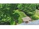 An aerial view showcases the lush backyard with mature trees, green lawn, and patio area at 6132 Sharon Rd, Charlotte, NC 28210