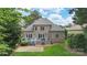 Brick home showcasing a large deck, a stone patio and a lush backyard at 6132 Sharon Rd, Charlotte, NC 28210