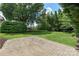 Large backyard with a lush lawn, mature trees, and a brick patio perfect for relaxing or entertaining guests at 6132 Sharon Rd, Charlotte, NC 28210