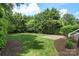 Expansive backyard featuring lush lawn, mature trees, and a stone patio perfect for outdoor entertaining at 6132 Sharon Rd, Charlotte, NC 28210
