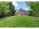 Brick home showcasing a large deck, a stone patio and a lush backyard at 6132 Sharon Rd, Charlotte, NC 28210