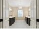 Elegant bathroom with dual sinks, a black-and-white tiled floor and modern chandelier at 6132 Sharon Rd, Charlotte, NC 28210