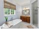 Well-lit bathroom with a standalone tub, wooden vanity, and a separate shower at 6132 Sharon Rd, Charlotte, NC 28210